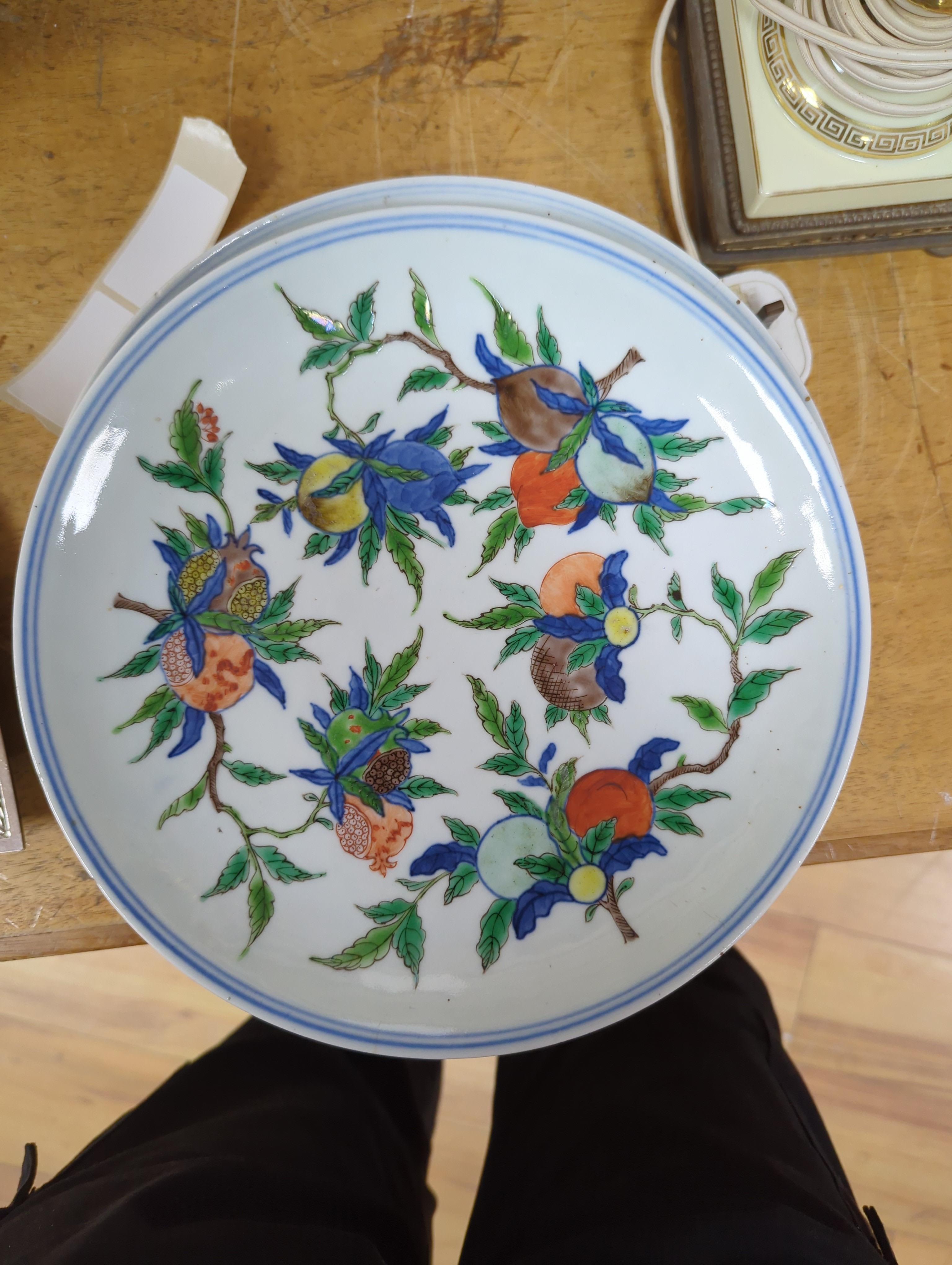 An 18th century Chinese famille rose bowl and a group of five Chinese wucai plates, each decorated with fruit, the bowl 23cm in diameter